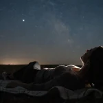 Person som tittar upp mot stjärnhimlen under meteorregnet Lyriderna