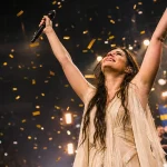 Kvinnlig artist på scen med konfetti fallande omkring henne efter Eurovision-seger
