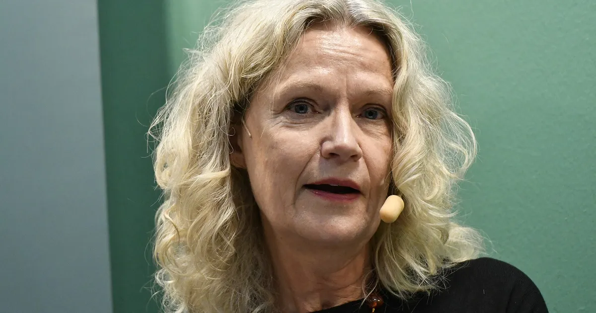 Person i mörkt rum med ansikte upplyst av mobilskärm, spänd och uppslukad