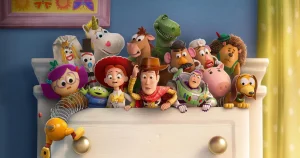 Toy Story-karaktärer samlade på en vit låda framför blå vägg. Woody, Buzz Lightyear, Mr Potato Head, Rex, Hamm och andra klassiska leksaker från filmserien pose