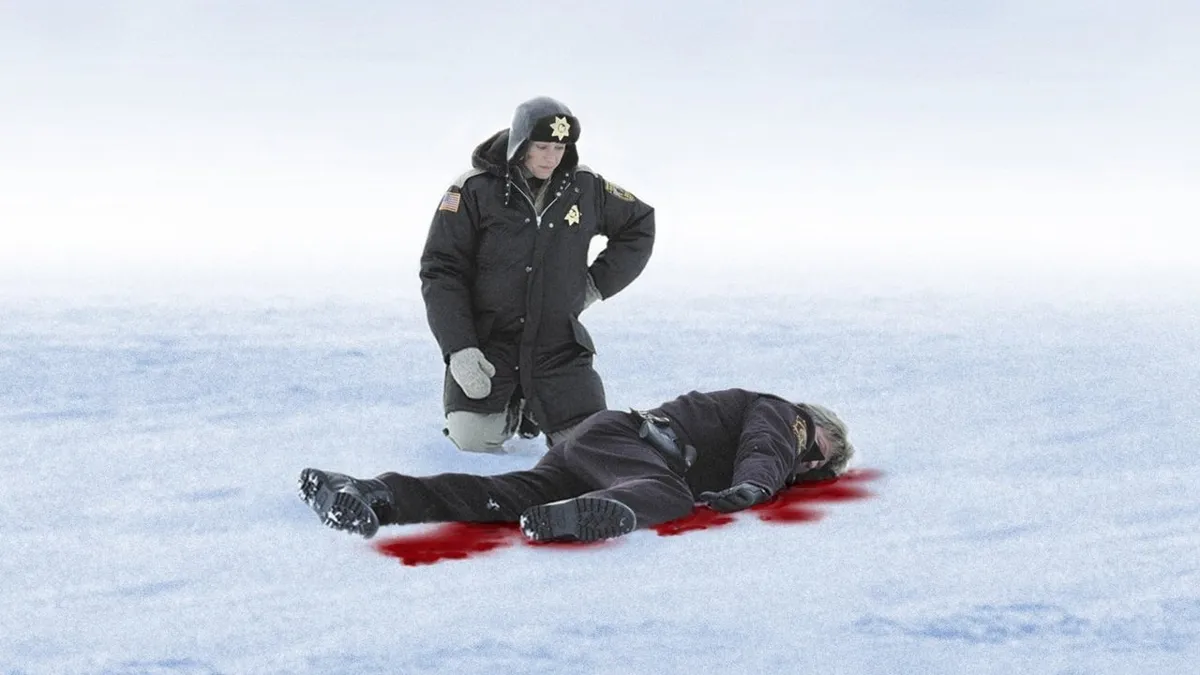 Polis står över liggande person på snötäckt is med blod runt kroppen.